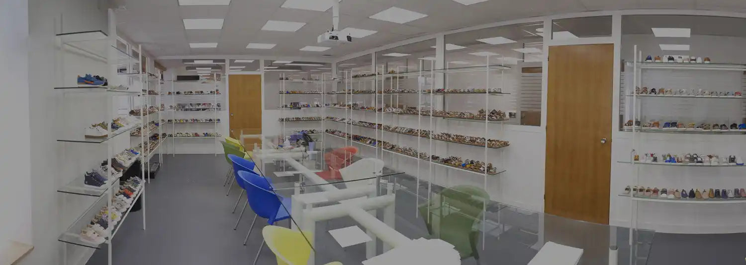 A shoe storage and display room with white shelves along the walls.