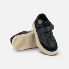 Baskets garçon Pom d'Api bleu marine en cuir avec semelle cuvette, lacets élastiques et fermeture velcro.